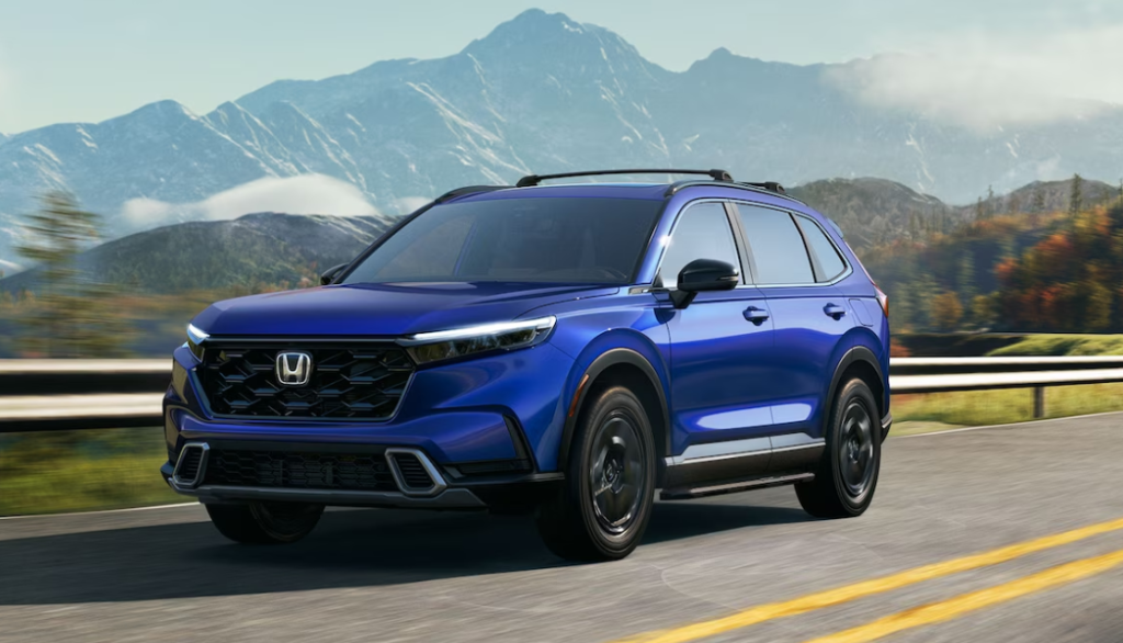 A blue new 2024 Honda CR-V is shown driving on the road.