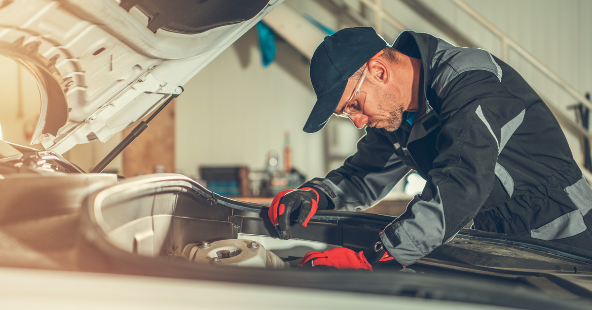 A mechanic servicing a Honda in the work shop.